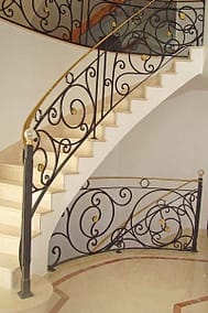 Handrail with round bronze top rail and bronze elements on scrolls