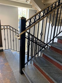 Railing with Bronze handrail and toprail with baskets in commercial building
